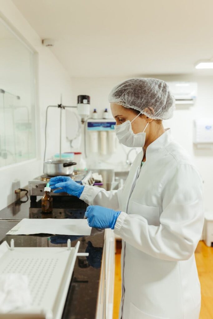 Female lab technician wearing protective gear conducting a scientific experiment.
