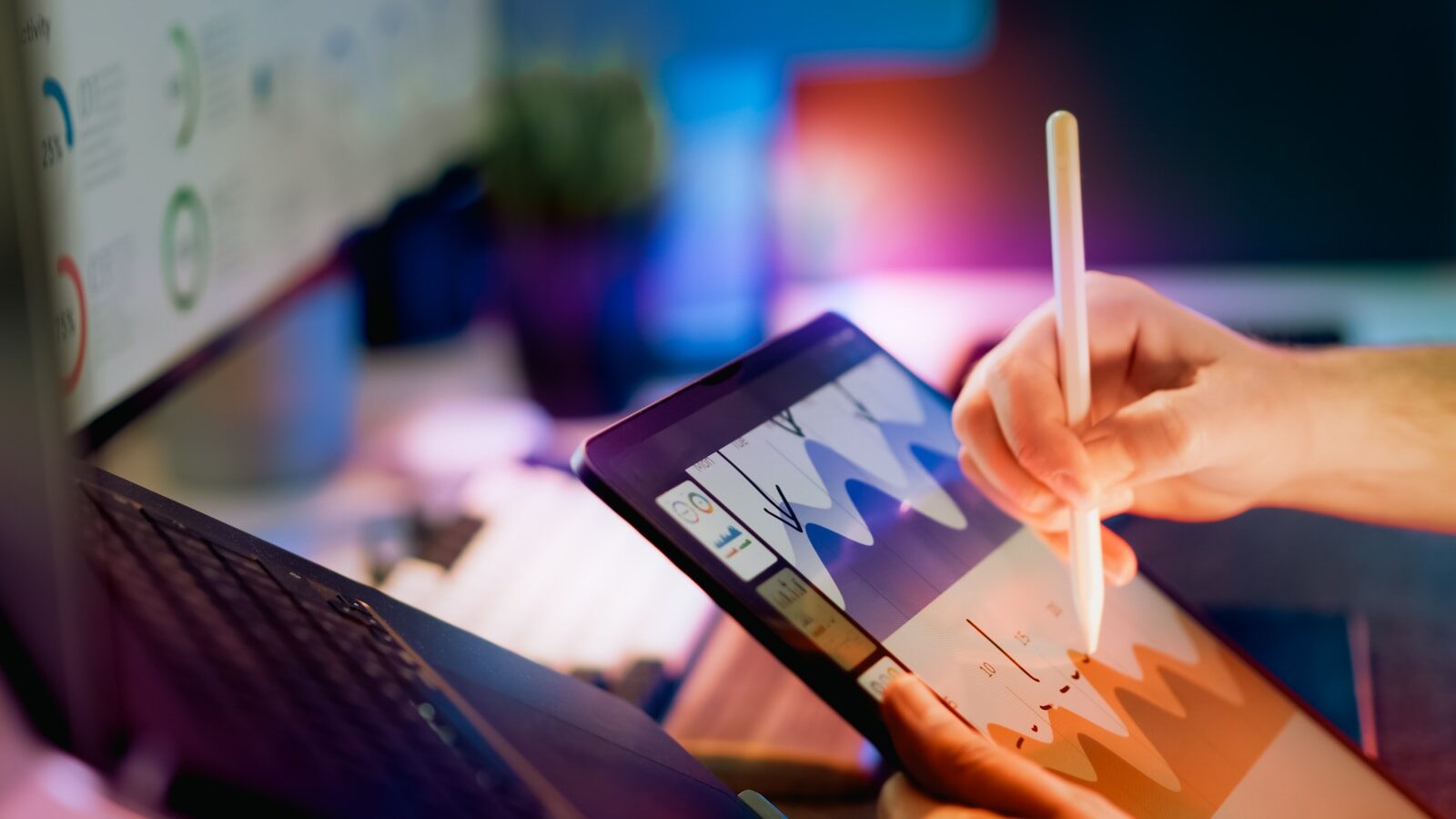 Person using stylus on tablet with charts